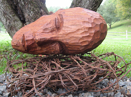 Suspended Sleep detail, burned oak, mahogany, cedar, barbed wire, stone, screws, steel clamps and cables, three heads installed at various heights each measuring 8”X18”X10” two heads installed on the ground measuring 6”X16”X8”